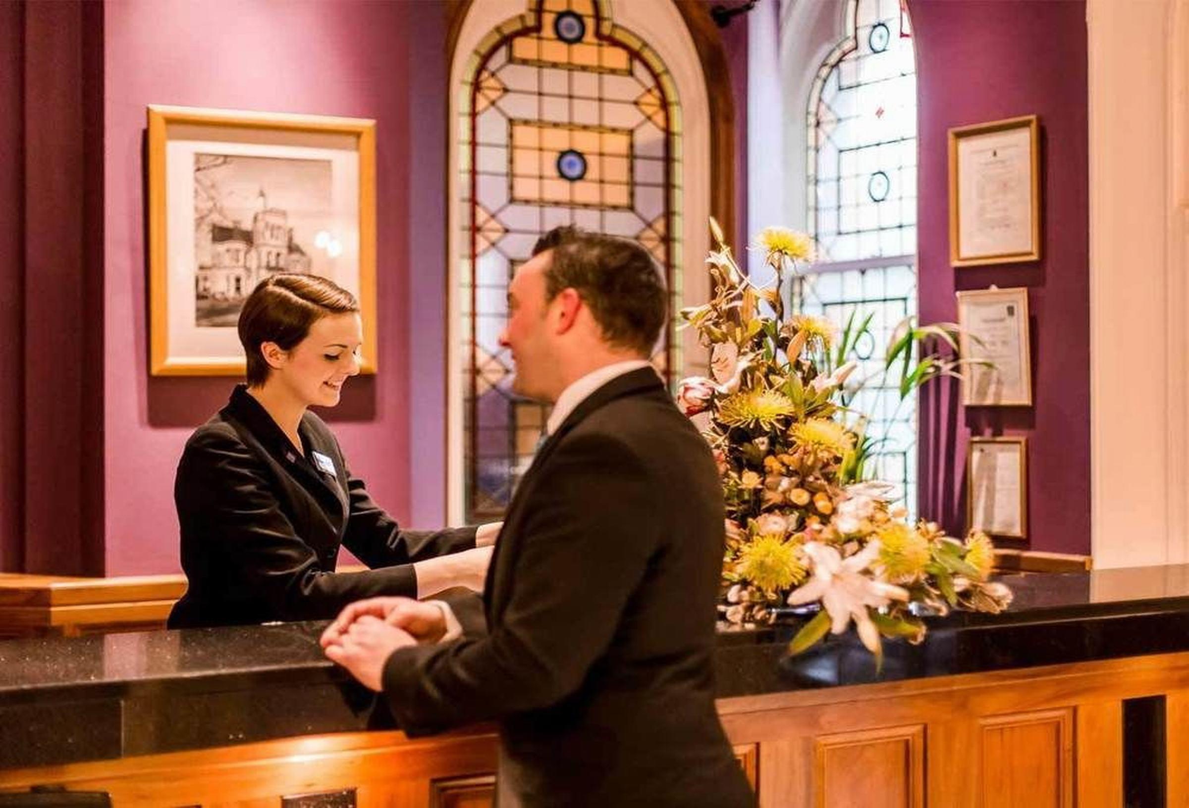 The Culloden Estate And Spa Холивуд Екстериор снимка A hotel receptionist at work
